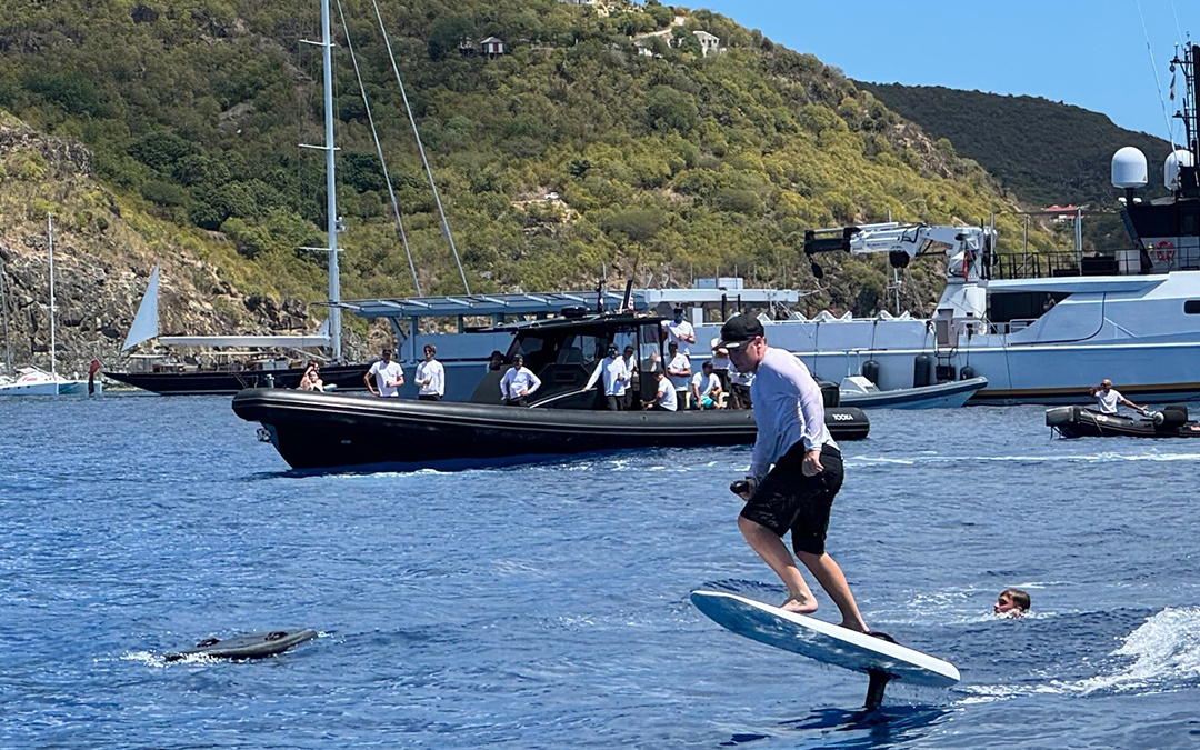 Photograph of a yacht crew member buzzing halfway around the St. Barths on an electric foil.